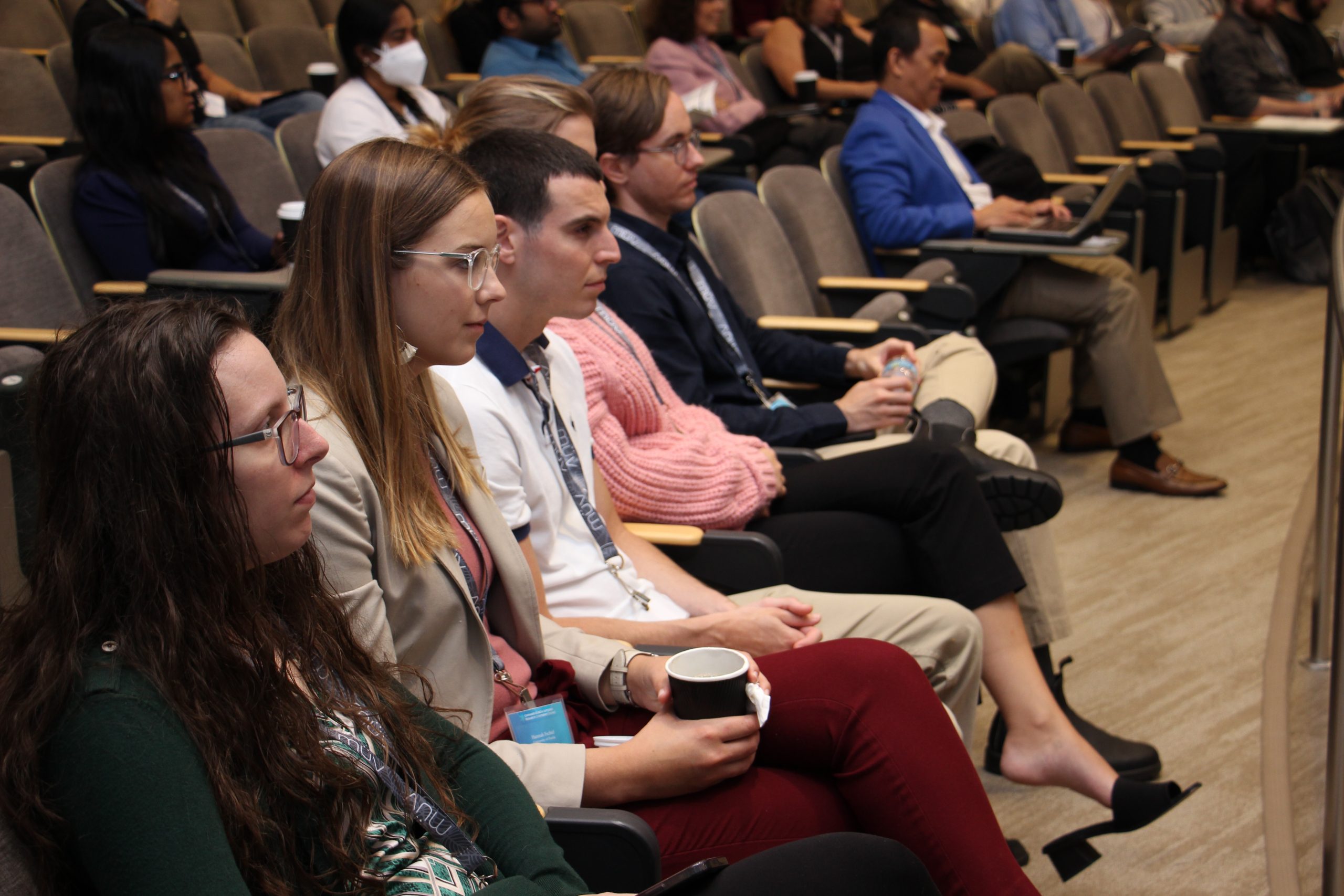 An audience of attendees sitting in a lecture hall